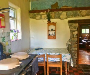 Range cooker and dining table with exposed brickwork behind