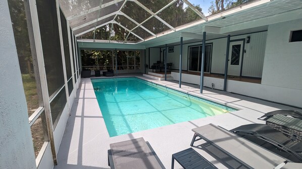 Screened Heated Pool with outdoor furniture, lounge chairs and outdoor dining