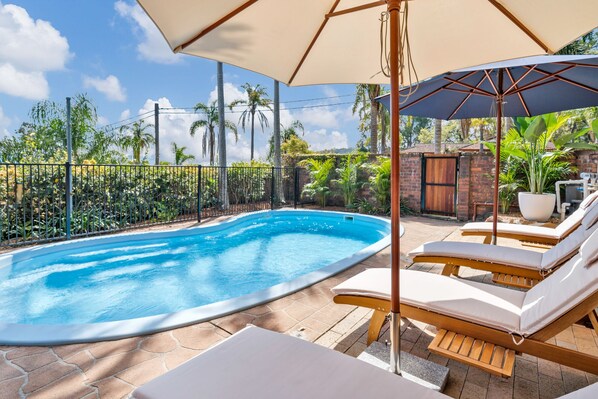 Splash in the pool and relax on sun lounges surrounded by greenery