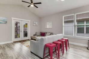 Full living room, with flat screen TV. Perfect for family vacations, or a couples getaway. Couch and loveseat. and living room attached to a kitchen with Island.