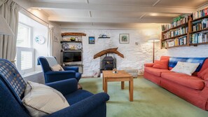 Lounge with wood burner effect fire, TV and book shelves