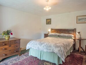 Bedroom with double bed, chest of drawers, bedside table and drawers with lamps