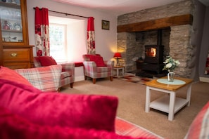 Sitting room with wood burner in inglenook fire place