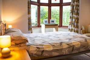 Double bedroom with bedside tables, lamps and occasional chair