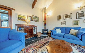 Two large blue sofas, sideboard and log burner