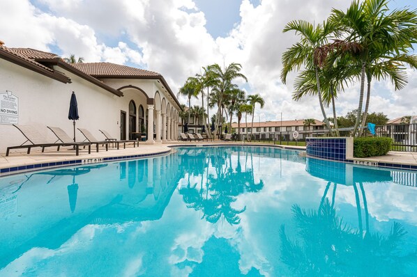 Resort style pool with loungers and umbrellas to cool off after a sunny South Florida day