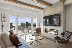 Relax in style in the spacious living room, featuring panoramic lake views and a cozy atmosphere for ultimate comfort.