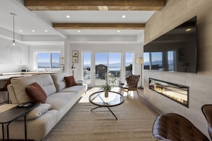 Relax in style in the spacious living room, featuring panoramic lake views and a cozy atmosphere for ultimate comfort.