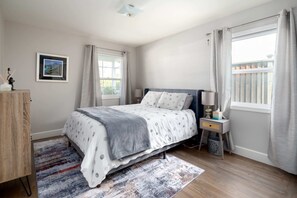 The bedroom has a comfy queen-sized bed, a dresser, and is tastefully appointed.