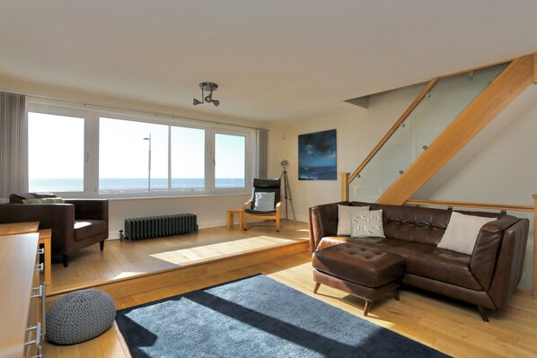 Open plan lounge area with panoramic sea and beach views