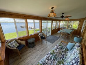 The screened sun porch.  Couch, two chairs, and a dining table that seats six.