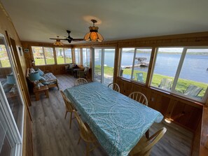 The screened sun porch.  Couch, two chairs, and a dining table that seats six.