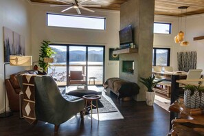Main level living room separating dining room with a see-thru fireplace.
