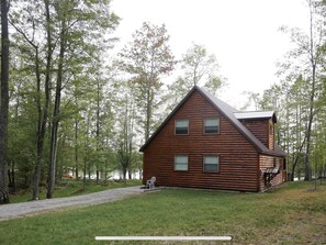 View of the home and lake from the parking area near the shed 