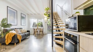Open plan living and kitchen with plenty of storage with stairs to bedroom