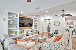 Spacious living room with big sectional, chairs and large SmartTV