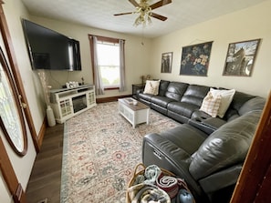 Family room with 70” TV.  Large sectional couch with dual recliners.