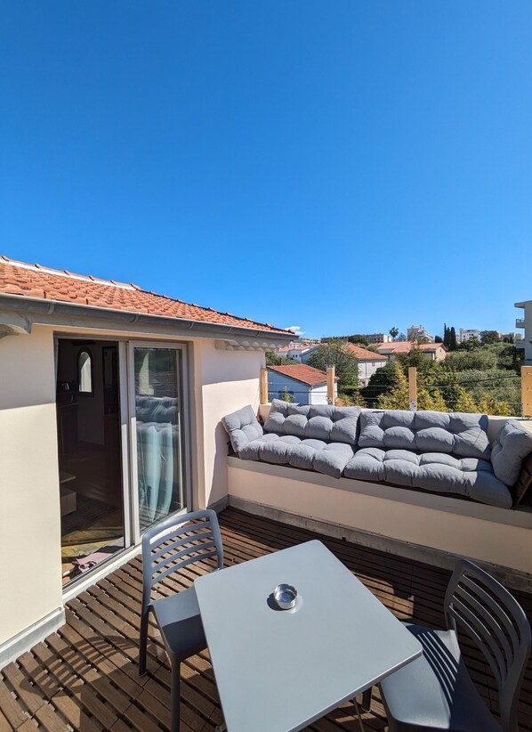 Private solarium terrace on the top floor with stunning views of the hills. A perfect space for a romantic getaway, long professional or student stays, or simply to relax in Juan-les-Pins.