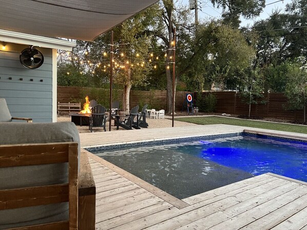 Cafe lights around the pool and firepit