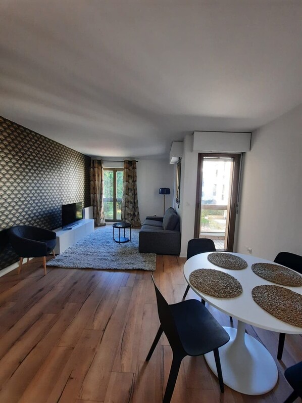 Spacieux salon donnant sur le jardin 
Accès balcon par la porte fenêtre de droite 
