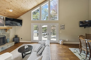 Open living, dining, and kitchen with multiple TVs so you don’t miss the action