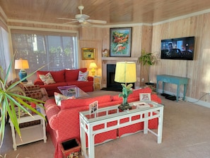 The main relaxing area, downstairs, with the TV, two sofas and two soft chairs.
