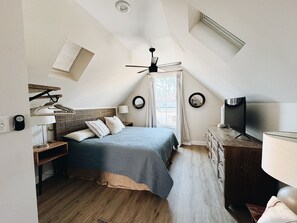 King size bed, Samsung TV, blackout drapes, and hanging rack for clothes.