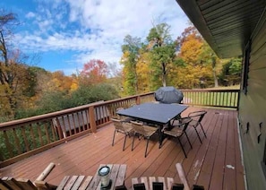 Back deck with grill overlooking fire pit and three acres of private woods.