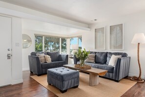 Bright and airy living room with peaks of the sand, ocean and palm trees! (front 2bd unit)