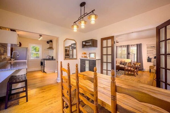 Farmhouse kitchen table with French doors leading into the living room.