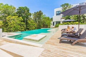 Shaded lounge chairs near one of the 3 pools at the property