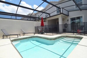 Sparkling private dip pool with loungers, shaded dining area, Adirondack chairs