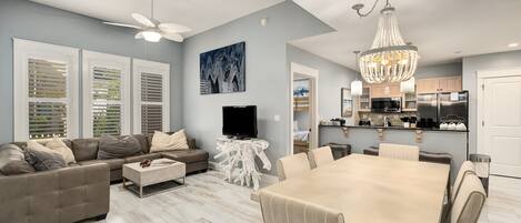 Modern living area with plenty of seating and natural light streaming through the shutters. The dining space flows seamlessly into the kitchen, making it easy to entertain while cooking.