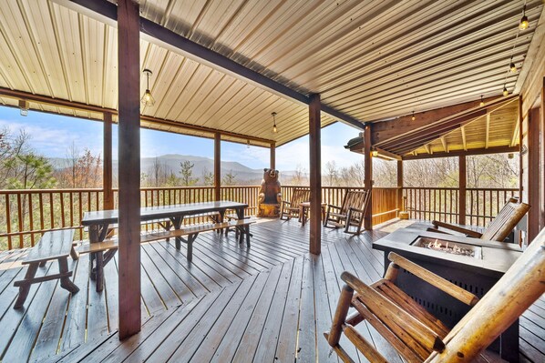 Spacious main deck featuring ample seating, mood lighting, and a propane fire pit—ideal for gatherings and stargazing.