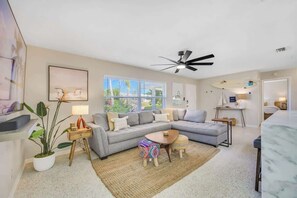 Living room area with sectional sofa and large TV.
