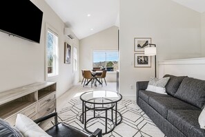 Lavish living room with seating for 4-5 people, and large Roku smart TV