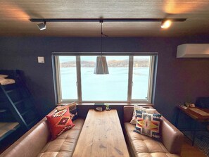 ・[Building C, living room] Vintage-style furniture and a picture-like window that perfectly captures the snow-covered grassland