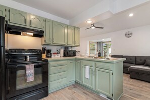 Kitchen view with coffee maker, microwave and living room view