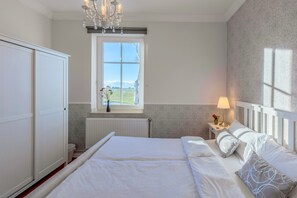 Doppelzimmer 6 mit neuen Ohrensessel. Am Horizont sehen Sie die Ostsee, Blick zum Hafen Thiessow und den Zicker Bergen