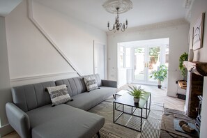 Bright and stylish living room with a cozy sectional sofa, fireplace, and garden access. Modern, spacious, and inviting.