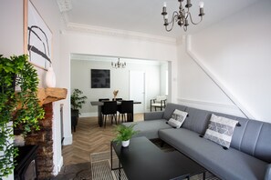 Modern open-plan living and dining area with a cozy sectional sofa, fireplace, and elegant decor. Stylish, spacious, and inviting.