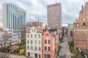 Urban city view with modern high-rise buildings and red-brick rooftops in the old town.