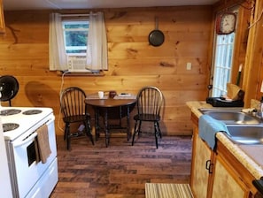 Quaint little kitchen with small dining table and three chairs