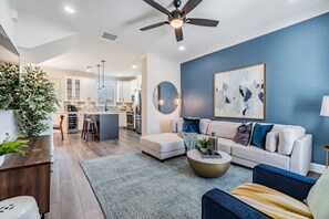 Cozy Living Room with Smart TV, board games, couch, armchair, throw blankets and pillows