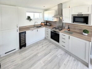 Kitchen with full-size fridge freezer, wine chiller, dishwasher, oven, microwave, and toaster. Fully equipped with crockery and cutlery | Hoburne, Bodmin