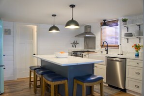 New kitchen appliances with in-island microwave and gas stove.