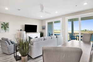 Indulge in the coastal vibe of this inviting living space, where comfort meets chic and every seat offers a view to serene landscapes