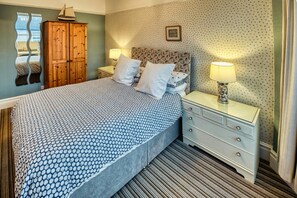 Kingsize bed with bedside drawers and lamps. Wardrobe and wall mounted mirror