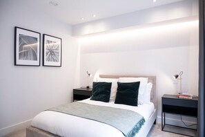 The bedroom features a floor-to-ceiling window,  a comfortable double bed (190 x 135 cm), and a spacious wardrobe.