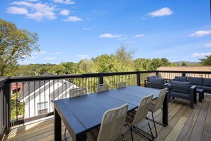 Large upper deck with outdoor dining area, coffee table, and lounging area